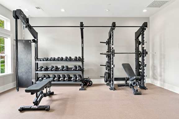 A well-equipped home gym with a variety of weightlifting equipment.