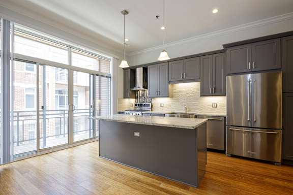 A modern kitchen with a large island and stainless steel appliances.