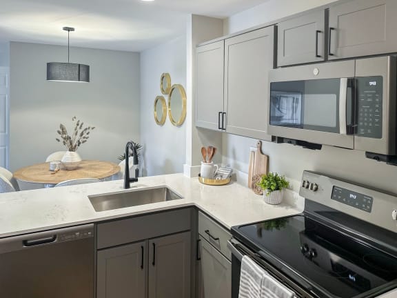 a kitchen with gray cabinets and a black stove top oven