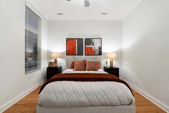 A bedroom with a large bed and two lamps.