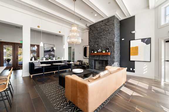 A modern living room with a stone fireplace and a large sectional sofa.