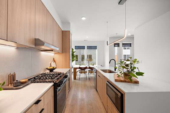 A modern kitchen with wooden cabinets and a white countertop.