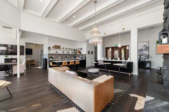 A modern living room with a large wooden coffee table in the center.