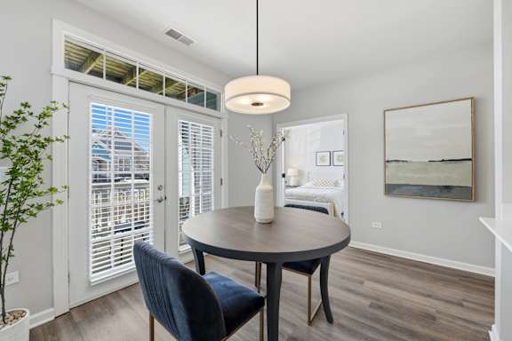 A dining room with a round table and a blue chair.