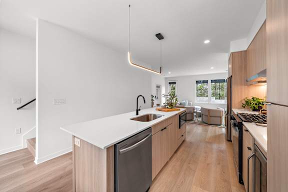 A modern kitchen with wooden cabinets and stainless steel appliances.