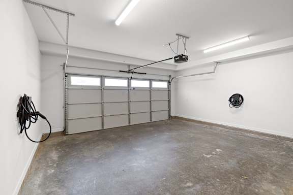 A garage with a concrete floor and a white wall.