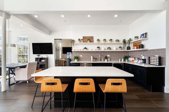 A modern kitchen with a white table and chairs.