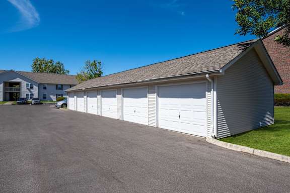 a white garage with white doors on the side of a driveway