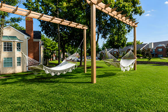 A white hammock is suspended between two wooden posts.