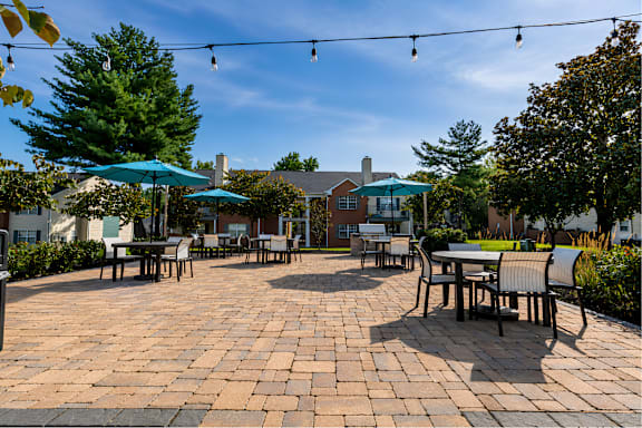 A patio with tables and chairs under umbrellas.
