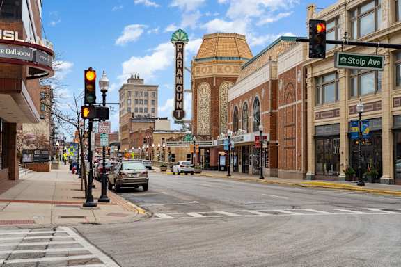 A city street with traffic lights and a Paramount Theatre sign.
