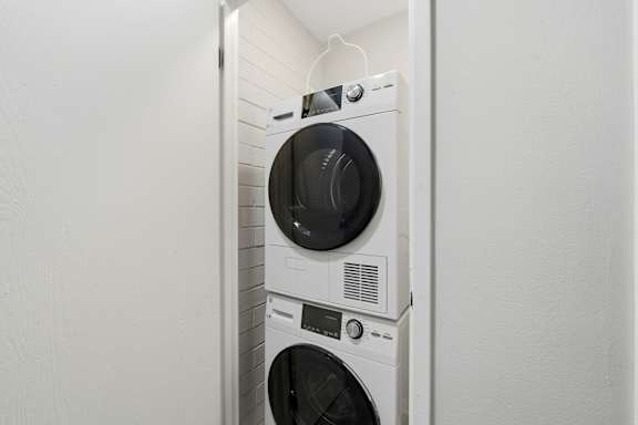 A white washing machine and dryer stacked on top of each other.