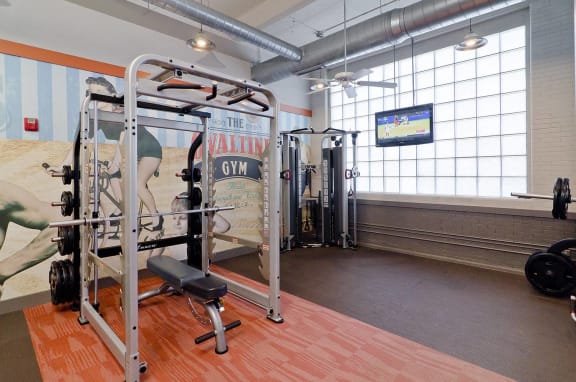 a home gym with a large window and wood flooring