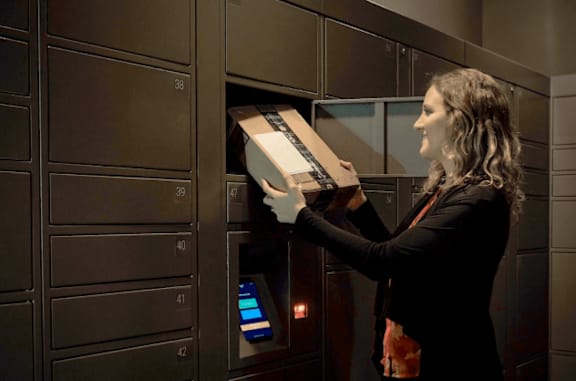 A woman is opening a safe in a room.