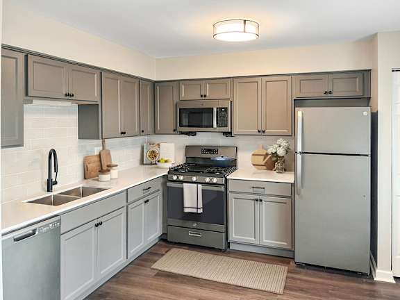 A kitchen with a stove, oven, refrigerator, and sink.