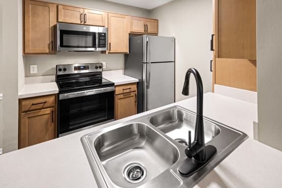 a kitchen with wood cabinets and stainless steel appliances