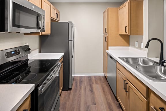 a kitchen with wood flooring and stainless steel appliances