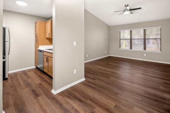 a kitchen and living room with hardwood floors and a ceiling fan