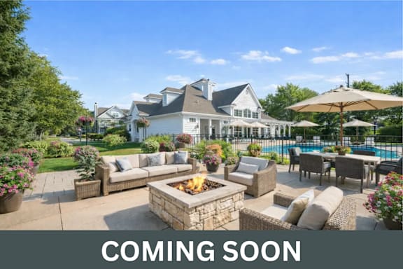 A large house with a pool and a patio with furniture.