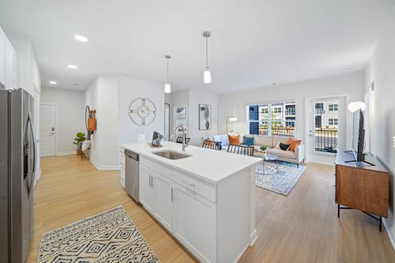 A kitchen with white cabinets and a black fridge.