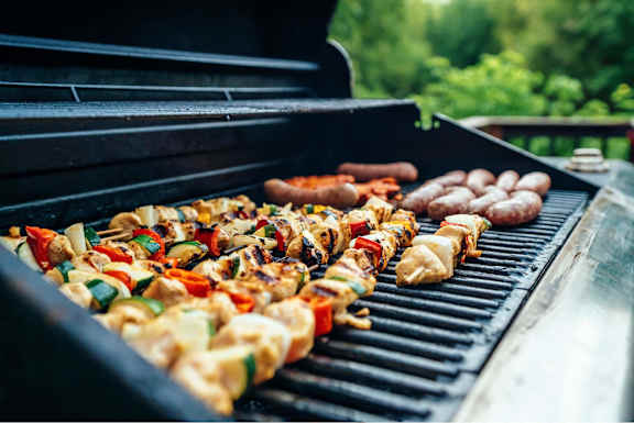 A variety of foods are being cooked on a grill.
