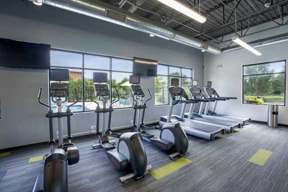 A gym with treadmills and elliptical machines.
