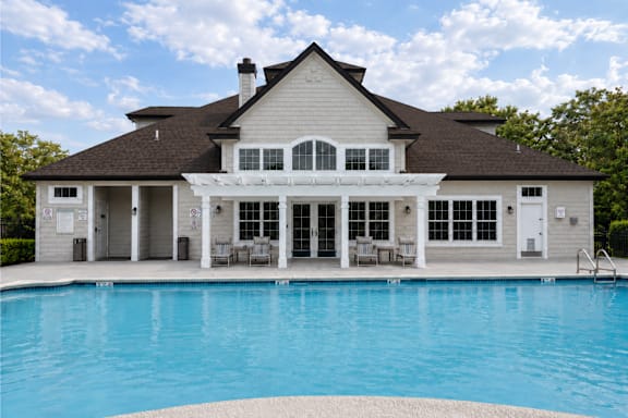 A large house with a pool in front.