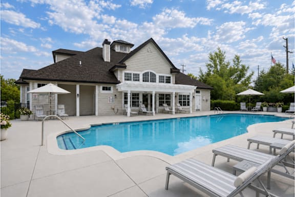 A large house with a pool in front.