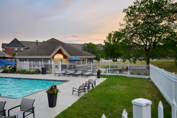 fence surrounding a grassy area and swimming pool behind the Valley Creek Apartments clubhouse