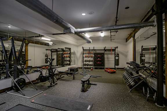 A gym with a variety of equipment including weights and weight machines.