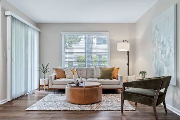 A living room with a white couch, a brown coffee table, and a green armchair.