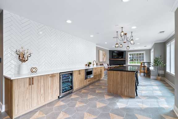 A modern kitchen with a black countertop and wooden cabinets.