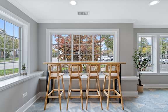 A kitchen with a table and chairs in front of a window.
