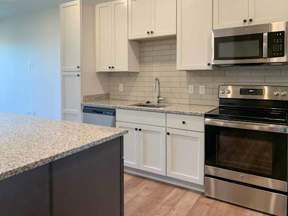 a kitchen with white cabinets and stainless steel appliances