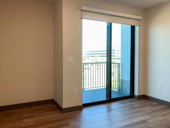 a living room with a sliding glass door to a balcony
