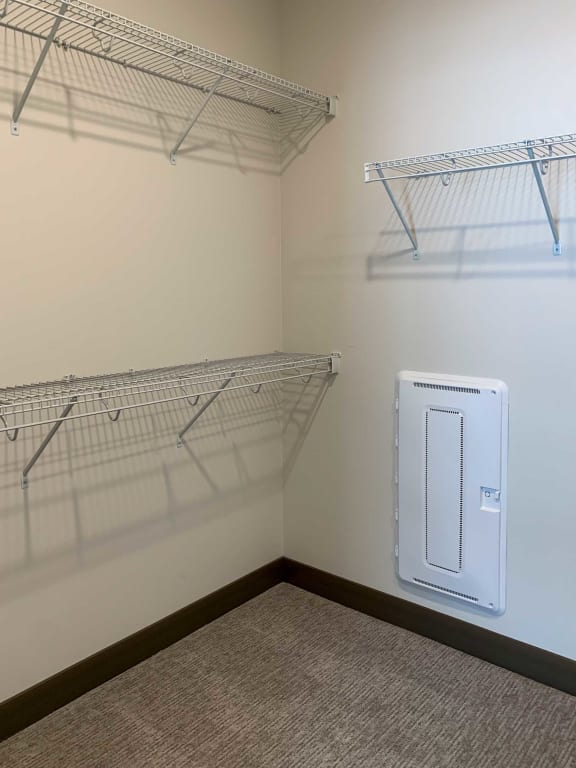 a utility room with shelves and a dryer on the wall