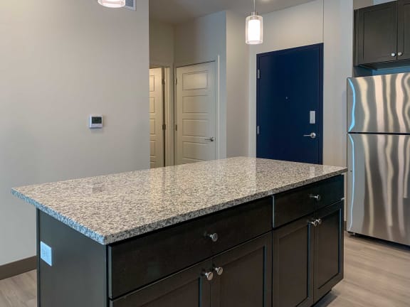 a kitchen island with a granite counter top