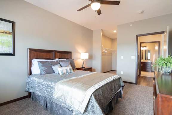 A bedroom with a large bed and a ceiling fan.