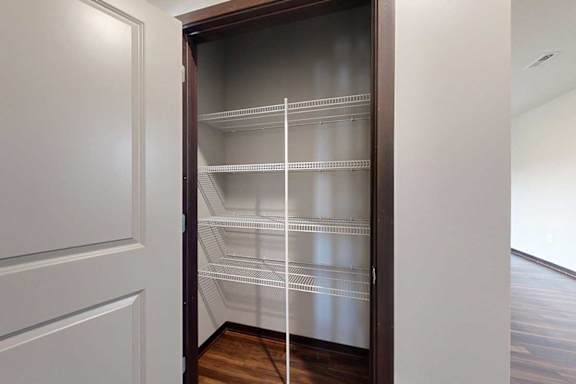 A hallway closet with built-in wire shelving, perfect for linens.