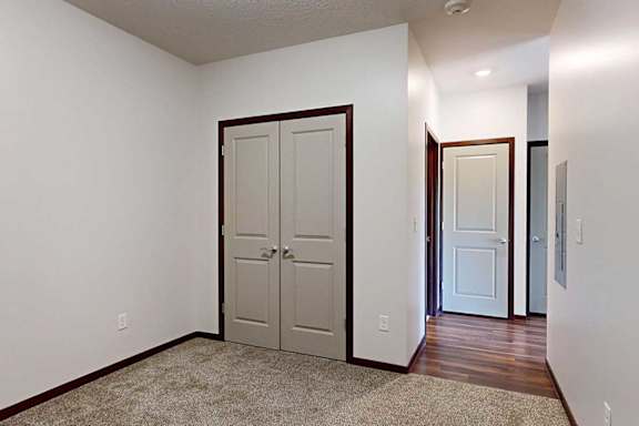 A den space with a closet double-door closet, and an opening to the hallway.