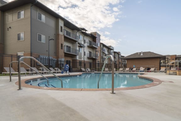 luxury resort style swimming pool with sun tanning lounge chairs at 360 at Jordan West