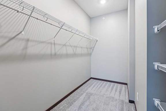An oversized walk-in closet with several built-in wire shelves.
