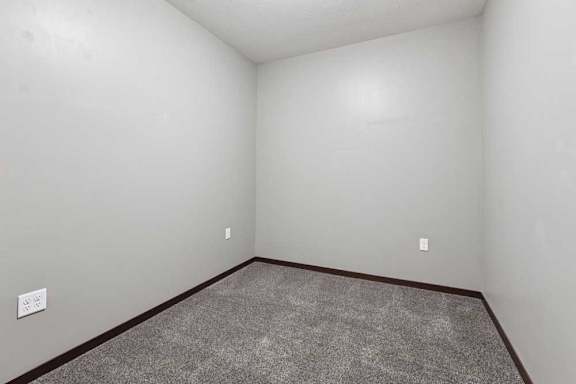 A carpeted den space with several outlets.