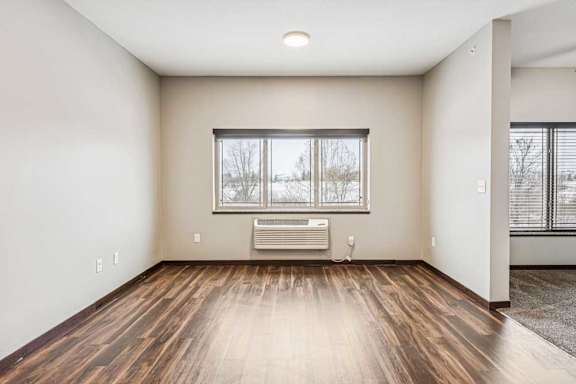 A living area with a three-panel window, and a doorway to a sleeping area.
