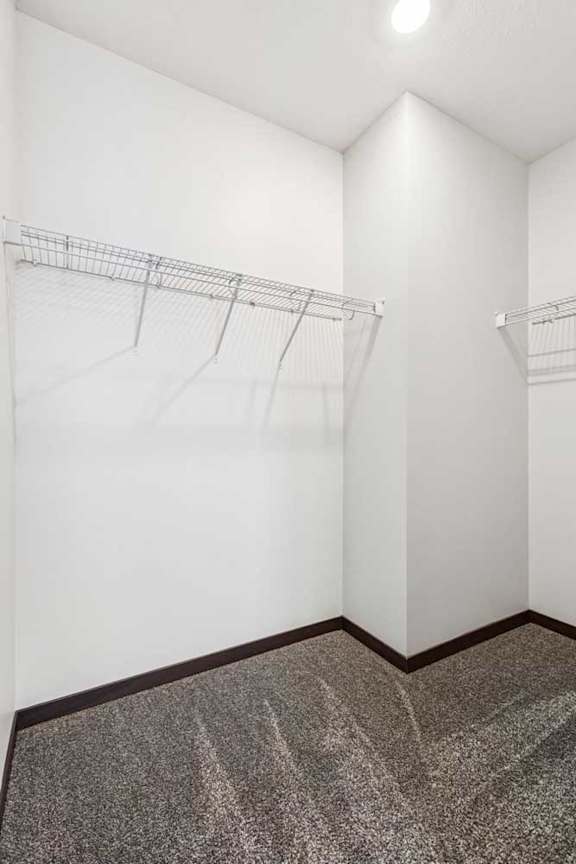 An oversized walk-in closet with several built-in wire shelves.