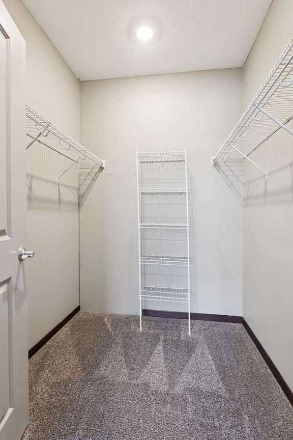 An oversized walk-in closet with several built-in wire shelves.