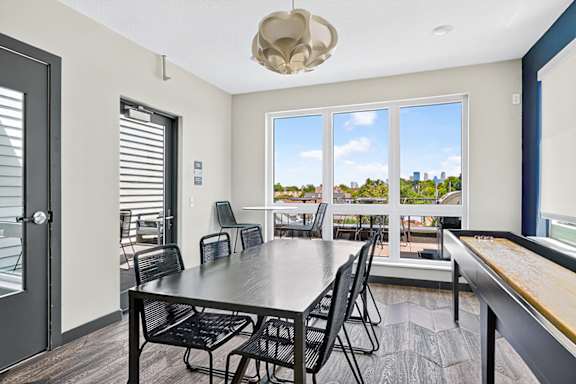 A dining room with a table and chairs and a view of the city.