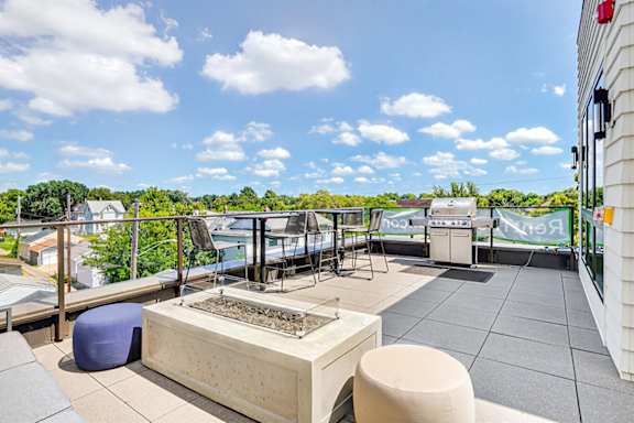 A patio with a grill and seating area.
