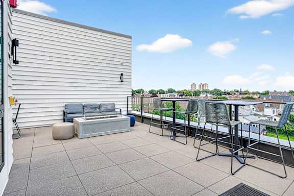 A patio with a table and chairs overlooking a cityscape.