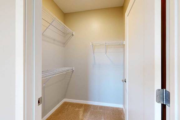 A spacious walk-in closet with built-in wire shelving.
